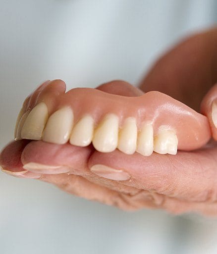 Handholding a full denture